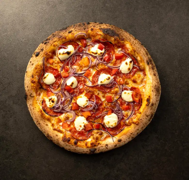 Pizza z pieca z pomidorkami, mozzarellą i ziołami, widziana z góry na ciemnym tle