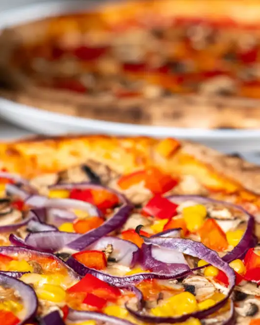 Dwie pizze i szklanka piwa na stoliku